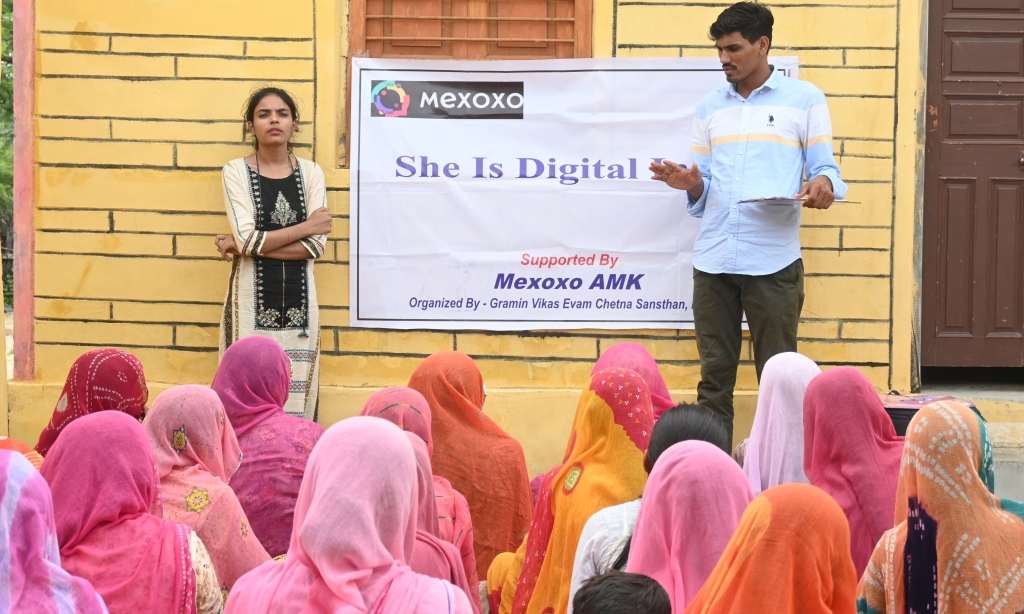 Image of women seated in front of a "She is Digital" banner